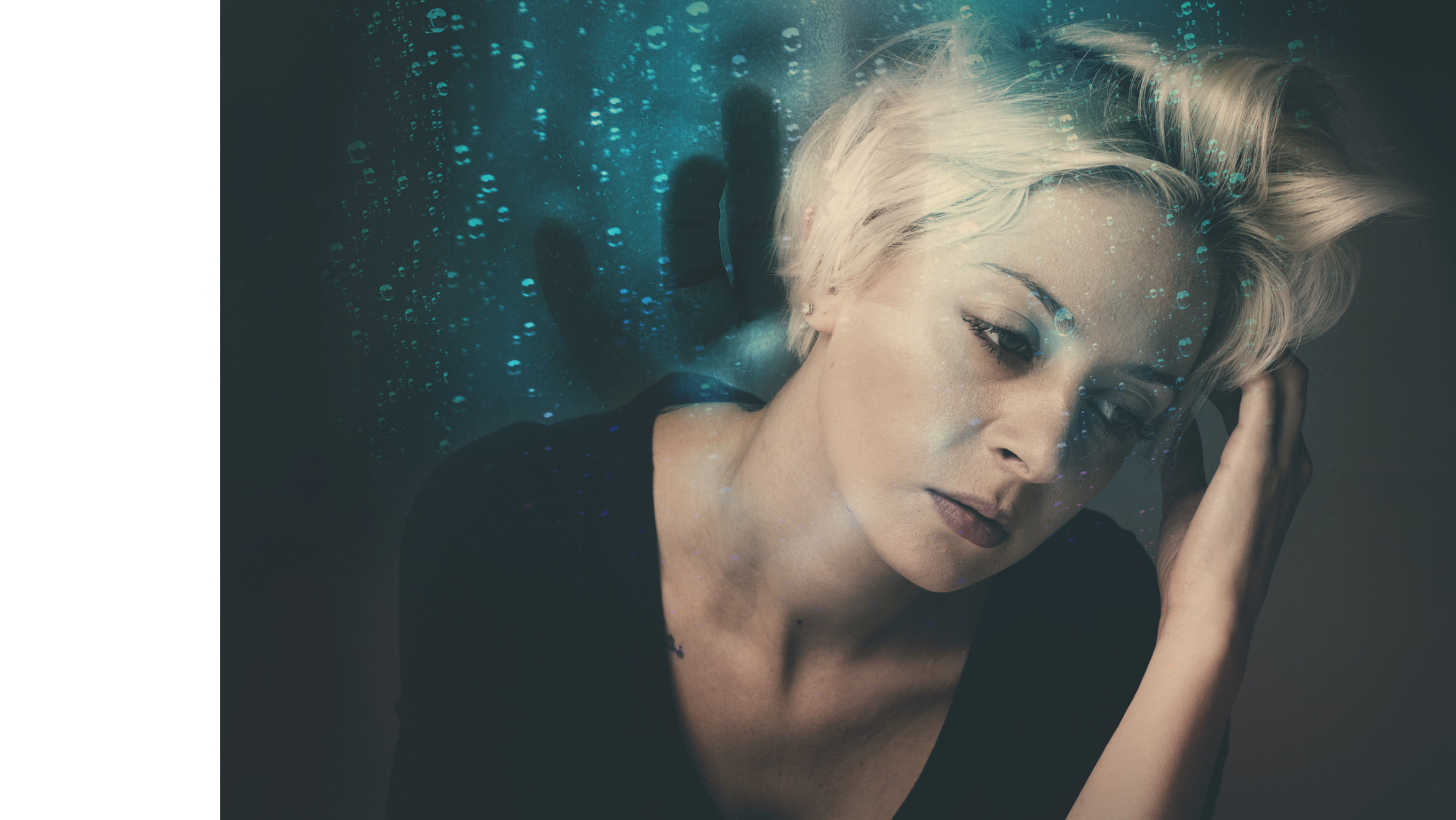 A woman sitting indoors, covering her had with her hands in a gesture that might express stress, sadness, or fatigue, seeking a moment of mental energy alignment.