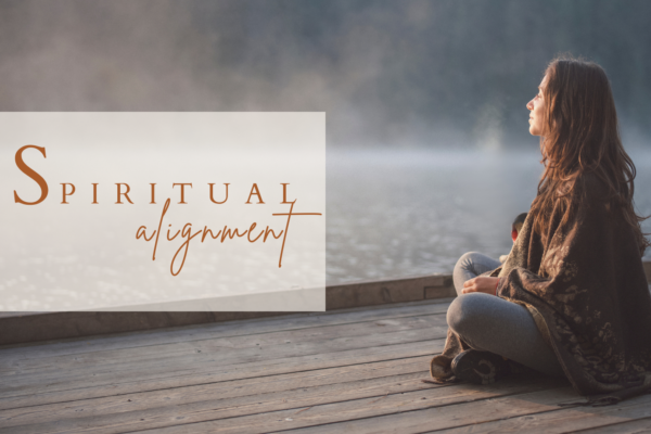 A woman embracing the warmth of the sun with sitting cross legged in a serene outdoor setting, symbolizing spiritual alignment and inner peace with text spiritual alignment